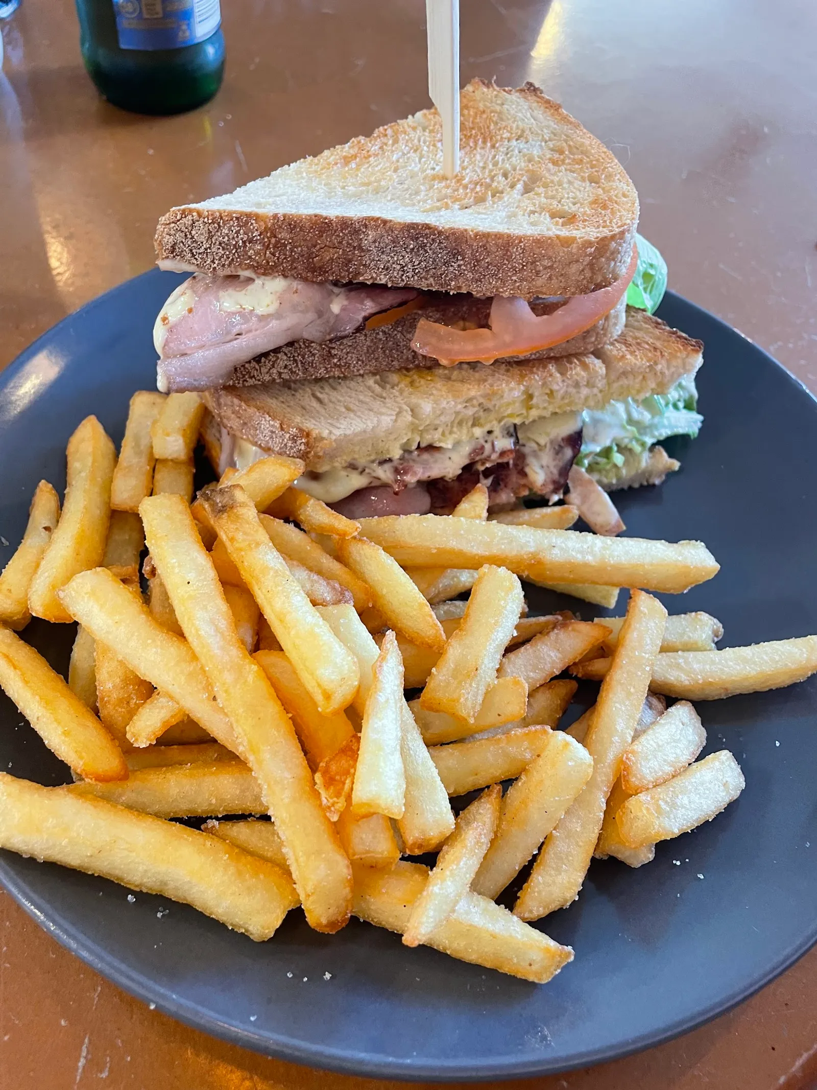 Club sandwich with chips on dark plate at Penny Lane Island Cafe